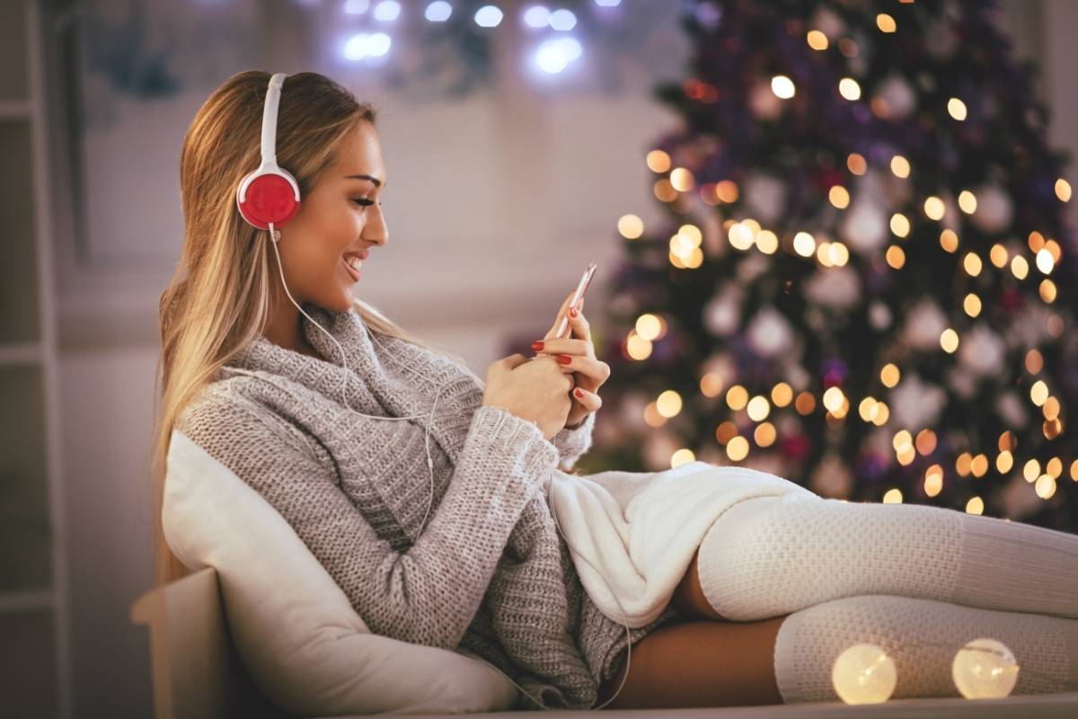 Woman on Couch Listens to Christmas Tunes