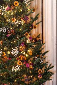 Citrus and flowers decorations on rustic christmas tree