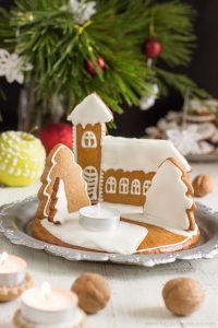 Gingerbread house on table with candle