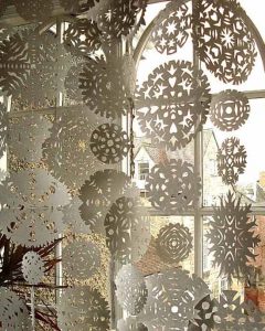 white paper snowflakes in window