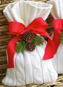 white fabric gift bag with red ribbon and greenery